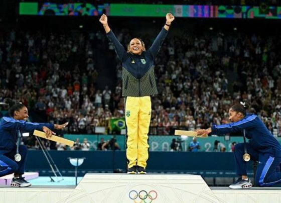 Rebeca Andrade en el podio olímpico, celebrando su medalla de oro en gimnasia artística, simbolizando la perseverancia y éxito